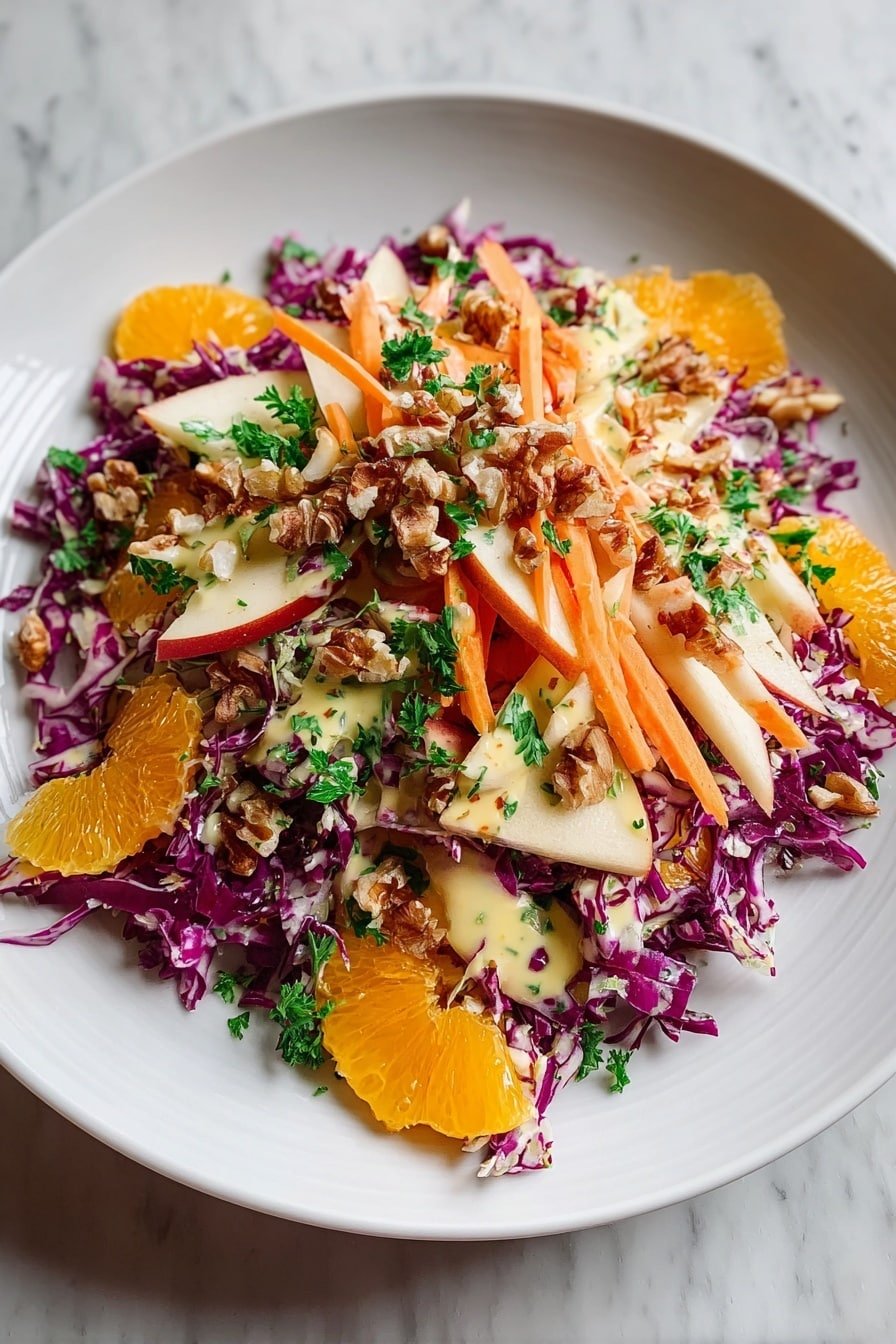 A white plate holds a colorful salad piled in the center. The bottom layer is finely sliced purple cabbage with shredded orange carrots placed unevenly on top. Scattered among these are thin apple slices and orange segments, adding light cream and bright orange colors. Small chunks of walnuts are spread over the salad, along with bits of dark red dried fruit, likely cranberries. The whole salad is topped with fresh green parsley and drizzled with a light yellow creamy dressing. The plate sits on a white marbled surface. Photo taken with an iphone --ar 2:3 --v 7 — Crunchy Apple Carrot Salad with Citrus Dressing, healthy colorful salad recipes, easy veggie salads, fresh fruit and vegetable salads, vibrant citrus dressings